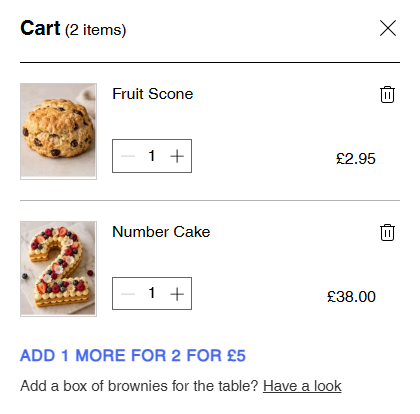 A side cart holding a Fruit Scone and a Number Cake, with “Add 1 more for 2 for £5” and beneath it “Add a box of brownies for the table? Have a look”